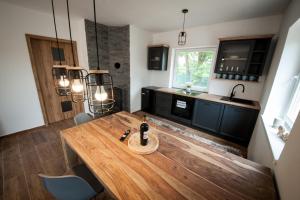 a kitchen with a wooden table with a bottle of wine on it at Apartmán na Žlábku in Horní Planá