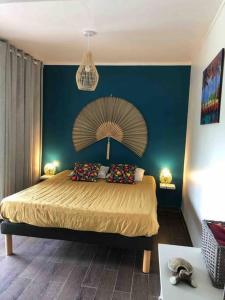 - une chambre avec un grand lit et un mur bleu dans l'établissement Villa Dezil - Villa de Standing 6/8 pers - Piscine, à Les Trois-Îlets