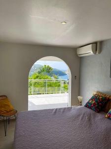 une chambre avec un grand lit et une grande fenêtre dans l'établissement Villa Dezil - Villa de Standing 6/8 pers - Piscine, à Les Trois-Îlets