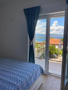 a bedroom with a bed and a view of the ocean at Bura in Jelsa