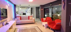 a living room with a couch and red chairs at Waterfront Glass Flat in Kusadası