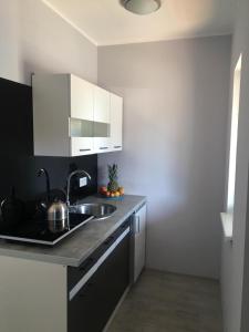 a kitchen with a sink and a counter top at Lazurowy Zakątek in Dąbki