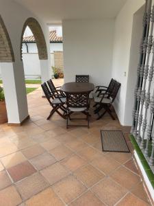 un patio con mesa de madera y sillas en LA BARROSA VILLA, en Chiclana de la Frontera