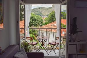 Habitación con balcón y vistas a una casa. en Studio Apartments Anija, en Dubrovnik