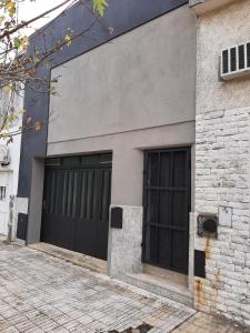 un edificio con dos puertas de garaje a un lado en Casa c/ Garage y Patio en Pergamino