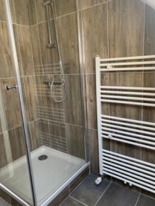 ein Bad mit einer Dusche und einer Glastür in der Unterkunft De oude hooizolder in Ulrum