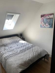 ein Schlafzimmer mit einem Bett in einem Zimmer mit einem Fenster in der Unterkunft De oude hooizolder in Ulrum
