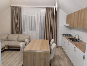 a kitchen and living room with a table and a couch at Guest house number 1 in Batumi