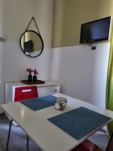 a room with a table and a tv on the wall at My Room Roma in Lido di Ostia