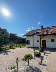 a house with a brick patio in front of it at Mazurska Sarenka in Wiartel