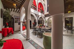 a restaurant with tables and chairs in a building at Riad Balkisse in Marrakesh