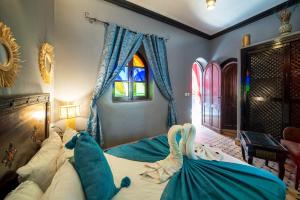 - une chambre avec un lit doté de draps bleus et une fenêtre dans l'établissement Riad Balkisse, à Marrakech