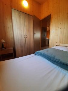 een slaapkamer met een wit bed en houten wanden bij Słoneczny Zakątek w Gąskach in Gąski
