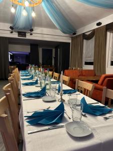 a long table with blue napkins and glasses on it at 1852 Landgasthof- Ferienwohnung in Elze