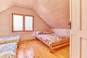 a room with two beds and a window at Omega Niechorze Domki Letniskowe in Niechorze
