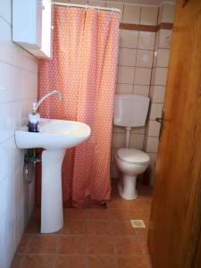a bathroom with a sink and a toilet and a shower curtain at Harmony by the sea - 20 meters from the sea in Kaloi Limenes