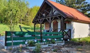 una piccola casa con una recinzione di fronte di Domek na wsi U Wiktora a Mikołajki