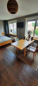 een woonkamer met een tafel en een bed bij Villa La Vida in Egmond aan Zee