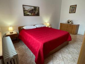 Schlafzimmer mit einem Bett mit einer roten Tagesdecke in der Unterkunft Appartamenti Allegrini Tuenno in Tuenno