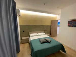 um quarto com uma cama com um cobertor verde em B&B Gisa House em Pomigliano dʼArco