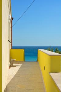a yellow wall with the ocean in the background at B&B Lu Cantoru in Marina di Pescoluse