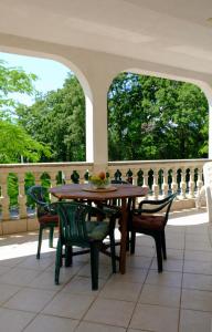 a wooden table and chairs on a patio at Apartments Ruzic Njivice in Njivice