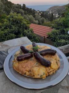 a plate of food with sausage on top of it at CASA DI PATOURIA , stenies Andros in Andros