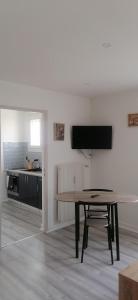 a living room with a table and a kitchen at Appartement avec balcon et parking privé in Roanne