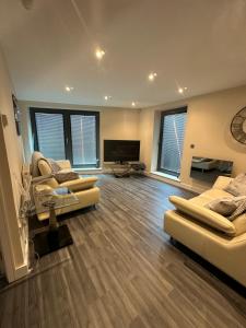sala de estar amplia con 2 sofás y TV de pantalla plana. en Bond Street Luxury Apartment Central Chelmsford, en Chelmsford