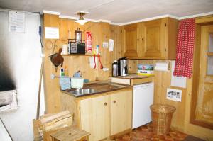 a small kitchen with wooden cabinets and a sink at Ferienhaus Brün in Valendas