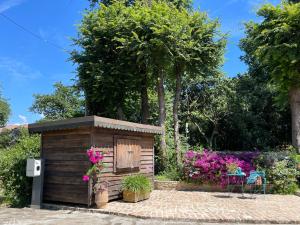 uma pequena casa de madeira com flores cor-de-rosa em Carpofoli Corfu em Corfu Town