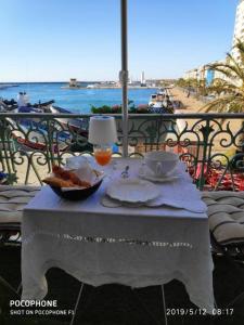 a table with a bowl of bread and a drink on a balcony at Ô 3 parasols in Sète