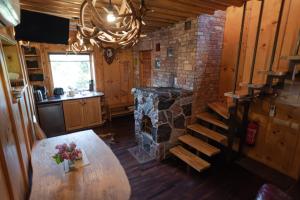 a kitchen with a wooden table and a stone fireplace at Pruuli Holiday Farm in Sõru