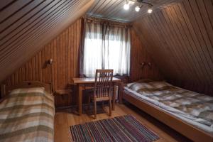 a bedroom with a desk and a bed and a window at Pruuli Holiday Farm in Sõru