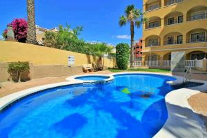 una gran piscina azul frente a un edificio en Apartment Fontana Golf Villamartin, en Orihuela Costa