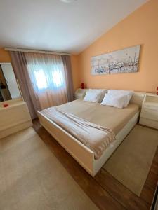 a bedroom with a large bed and a window at Village house Iva in Virpazar