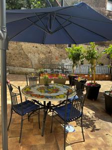 una mesa con sillas y una sombrilla en el patio en CASA MARIA, en Cetara