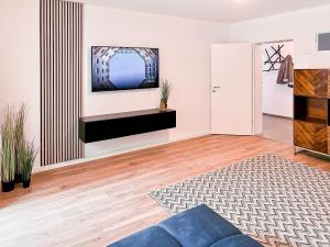 sala de estar con TV en la pared en Apartment nähe Legoland Deutschland mit Terrasse, en Günzburg
