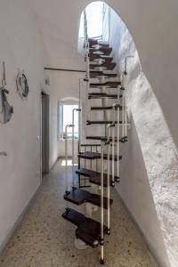 TerzorioにあるAgriturismo Il Vecchio Mulinoの白壁の部屋の螺旋階段