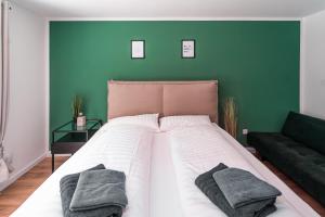 Cama grande en habitación con pared verde en Apartment nähe Legoland Deutschland mit Terrasse, en Günzburg