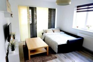 a small bedroom with a bed and a table at Relaxing Coresi Place in Braşov