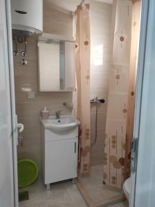 a bathroom with a sink and a shower at Apartmani CECA 012 Sutomore in Sutomore +68 photos