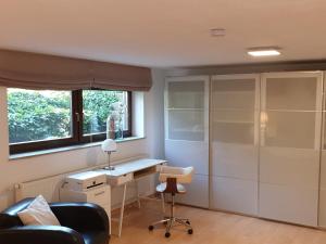 een kamer met een bureau, een stoel en een raam bij Radebeul mit Flair in Radebeul