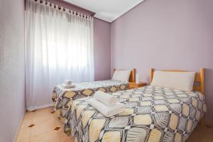 ラ・マタにあるPlaya la Mata - Apartamento "Limonka"のベッド2台が隣同士に設置された部屋です。
