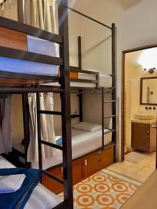 a room with bunk beds with a sink and a mirror at Hotel & Hostal Boutique Casa Garza in Mérida