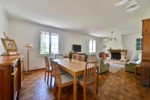 ein Esszimmer mit einem Tisch und Stühlen sowie ein Wohnzimmer in der Unterkunft Villa Marie-Rose in Saint-Didier