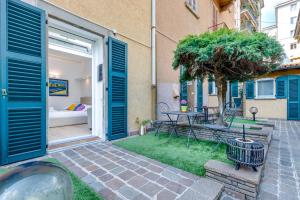 a building with blue doors and a courtyard with a table at FEEL - Patio del Sole in Bergamo