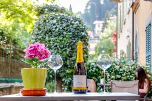 a bottle of wine sitting on a table with a flower at FEEL - Patio del Sole in Bergamo