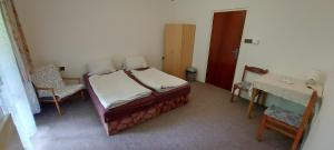 a bedroom with a bed and a table and a desk at Penzion Svojanov in Svojanov