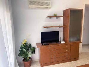 TV en un tocador de madera en una habitación en VenAMarinador Playa Costa Caribe I - 267 - 2 Dormitorios/1 Baño WIFI, en Oropesa del Mar
